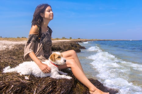 Young gal with her dog by the beach. Young gal with her dog by the beach.